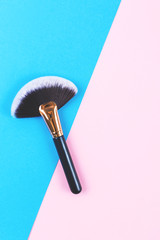 Minimal composition of a fan brush on blue and pink background.  Flat lay, top view. Copy space for your text.