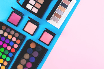 Many makeup products on blue and pink background.  Flat lay, top view. Copy space for your text.