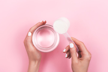 Woman hands with a scoop with collagen or protein powder.  Flat lay, top view. 