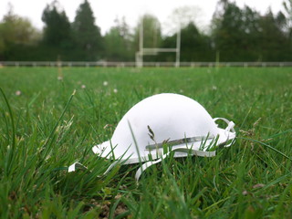 Protective mask thrown in the middle of a rugby field