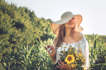 How to Harvest and Dry Herbs. Traditional medicinal plants. Woman picking flower in summer field with sunlight ray