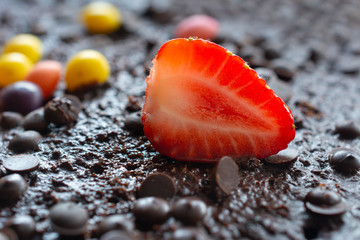 Slice of fresh strawberry on chocolate background