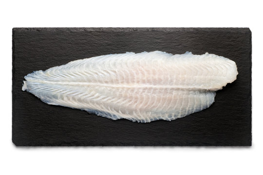 Basa Fish Fillet On A Black Stone Plate, Isolated On White Background, Top View.