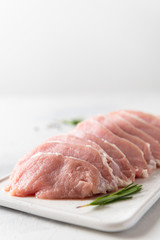Raw pork meat. Fresh steaks on white board on white background. Side view, copy space. Dieting, nutrition