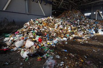 Solving problem of environmental pollution with waste at garbage processing plant huge pile of garbage prepared for loading to conveyor belt for further sorting and processing with copyspase.
