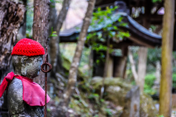 Symbol of buddhism, small statuette in a forest in Hiroshima, Japan