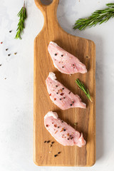 Raw meat. Raw beef steak on a cutting board with rosemary and spices. Top view