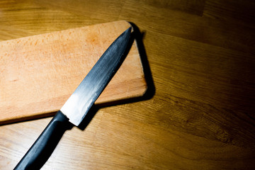 Knife and wooden board on the table