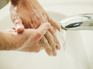 hands in soap under the tap with water close-up