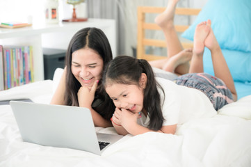 Fototapeta premium work from home, 2 sisters are working on laptop at home