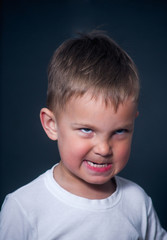 offended and nervous boy on gray background