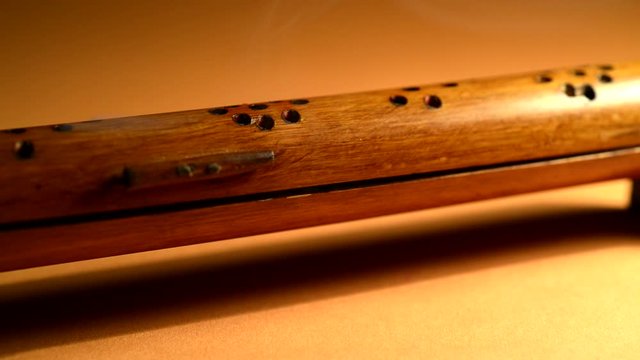 Smoke comes out of a bamboo holder in which the incense stick burns.