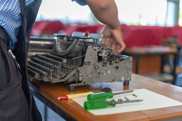 Close up photo of vintage manual typewriter being fixed by a repairman
