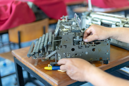 Close up photo of vintage manual typewriter being fixed by a repairman
