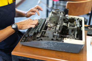 Close up photo of vintage manual typewriter being fixed by a repairman
