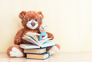 toy bear reading an interesting book, showing that even read toys. the concept of baby learning