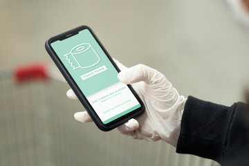 Woman wearing a latex glove while using cellphone to prevent coronavirus contamination mockup screen