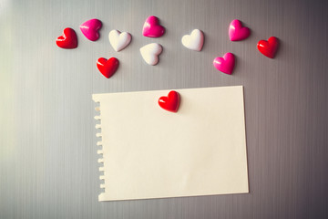 Abstract of wooden heart clip with Blank paper and stick paper on refrigerator door. paper note...