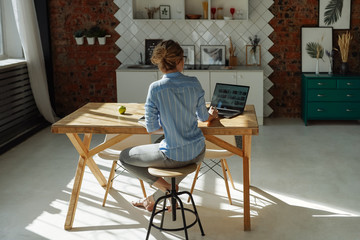 Back view of a girl studying at home. Online design lesson. Sharp long shadows