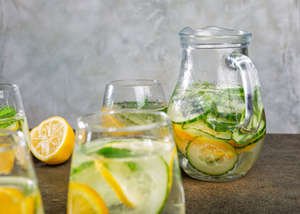 Cold homemade summer healthy diet detox lemonade, cocktails of citrus infused water or mojitos, with lime lemon orange, ice and mint, copy space