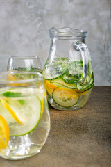 Cold homemade summer healthy diet detox lemonade, cocktails of citrus infused water or mojitos, with lime lemon orange, ice and mint, copy space