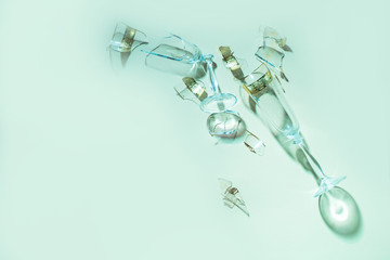 Two broken glass glasses lie on a colored background with tattical shadows.