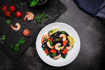 Squid Ink Pasta With Seafood, Herbs, Cherry Tomatoes. Black Spaghetti, Black Organic Noodles with Shrimps. Mediterranean gourmet food.