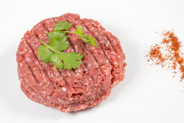 steak haché de boeuf cru sur un fond blanc