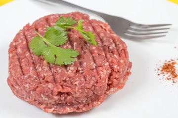 steak haché de boeuf cru sur un fond blanc