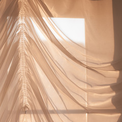 Elegant, thin transparent curtain on the window, by sunlight. Selective soft focus.