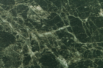 Texture of dark green marble for tabletop with olive lines of a pattern, macro background....