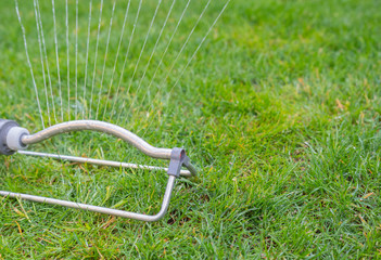 Gras berieselung mit Wasser in der Trockenheit