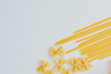 Variety of types and shapes of Italian pasta in rows on white background. Italian cuisine food. Dry pasta background texture.