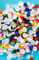 Top view of huge number of plastic bottle caps of different sizes, shapes and colors. Plastic recycling concept.