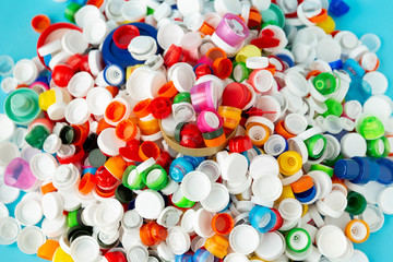 Fototapeta na wymiar Top view of huge number of plastic bottle caps of different sizes, shapes and colors. Plastic recycling concept.