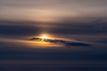 Fototapeta na wymiar Barely visible sun behind the clouds