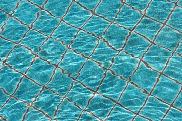 Blue swimming pool tiles with ripples and reflections