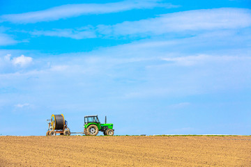 Obraz premium Traktor mit Anhänger auf dem Feld