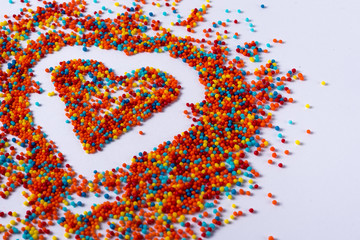 bigger bright colored heart made of colorful balls on a white background Defocus. Bokeh with place for your text.
