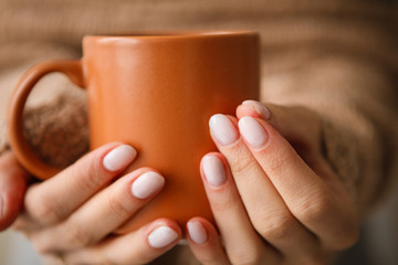 Women's hands with a cup of coffee.