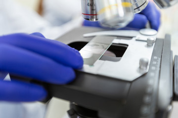 Scientist using microscope with slide sample coronavirus or covid-19, Concept science and Technology