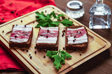 Three brown bread sandwiches with parsley and black peppercorns