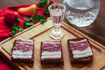 Three brown bread sandwiches with sweet peppers, parsley and vodka shot glass