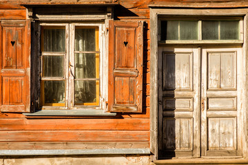 Obraz na płótnie Canvas windows with open shutters and closed doors of an old wooden building