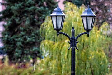 close up view on decorative old metal lamp on a blurred green background