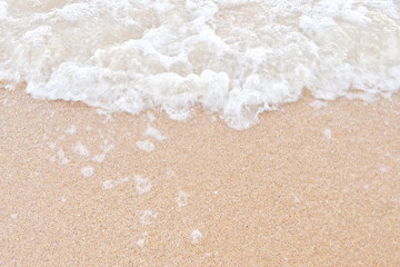 Fototapeta na wymiar Closeup of beautiful white shiny sea waves on the beach in the morning for relaxation