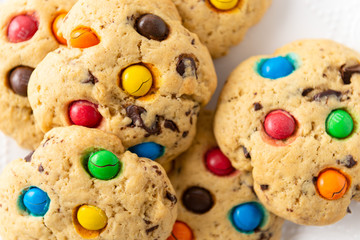 Homemade vanilla cookies decorated with multi-colored candy drops on white background. Top view, close up