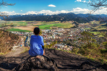 Naklejka premium Boy looking from top of the hill at city
