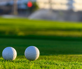 Excellent well-kept green grass lawn on large golf course, green section with big white foam balls for beginners on Tenerife island, Canary, Spain