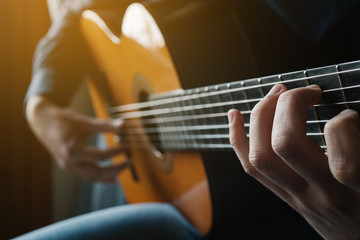 Fototapeta na wymiar Man playing acoustic guitar. Practicing guitar. Modern young man playing.